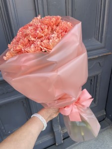 BUKIET POMARAŃCZOWYCH GOŹDZIKÓW OWINIĘTYCH MATOWYM WODOODPORNYM PAPIEREM